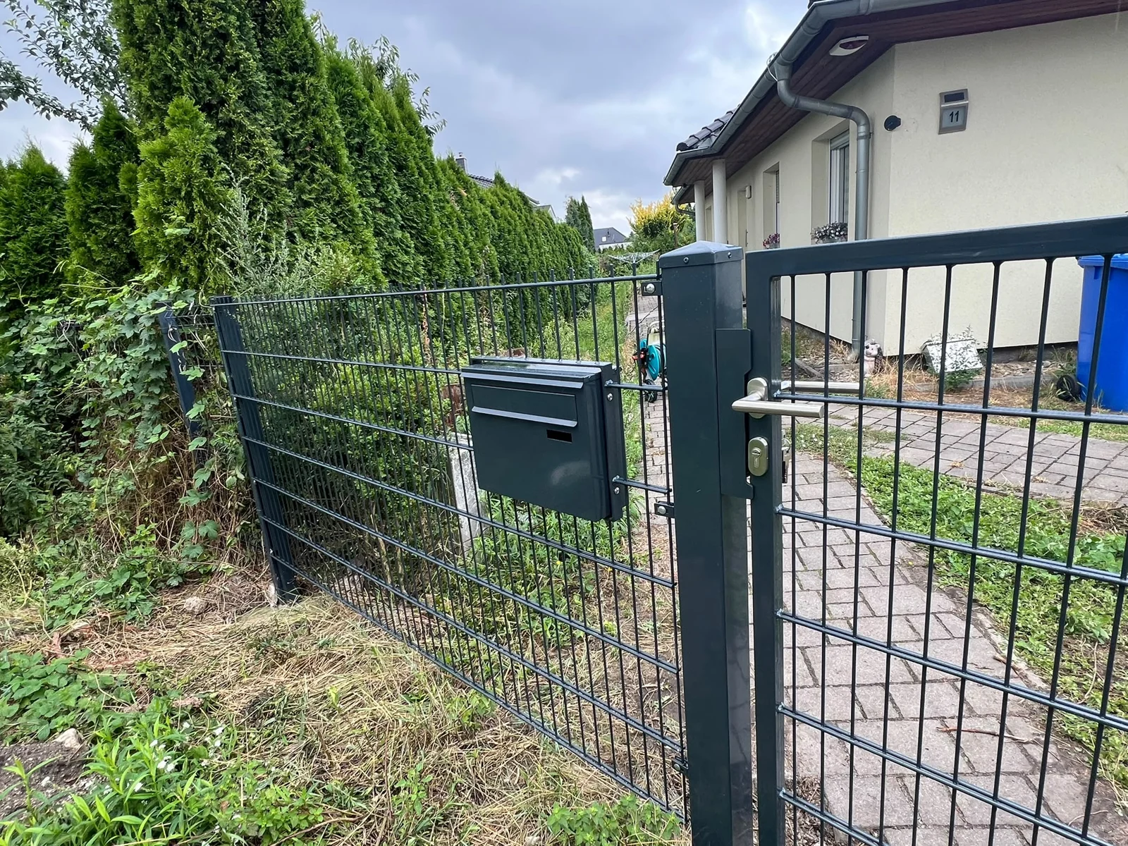 Anthrazitfarbener Doppelstabmattenzaun mit Gartentür an einem Wohnhaus